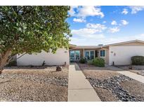 Front view of a single-story home with a walkway, landscaping, and rock garden at 19019 N Camino Del Sol --, Sun City West, AZ 85375