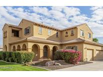 Two-story house with a large front yard, landscaping, and a three-car garage at 21525 E Camacho Rd, Queen Creek, AZ 85142