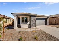 New construction home with gray exterior, stone accents, and a two-car garage at 37566 W San Clemente St, Maricopa, AZ 85138