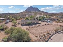 Aerial view of a ranch-style home with a corral, mountain backdrop, and ample parking at 47435 N Meander Rd, New River, AZ 85087