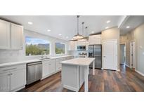 Modern kitchen featuring white cabinets, island, and stainless steel appliances at 5089 E 26Th Ave, Apache Junction, AZ 85119