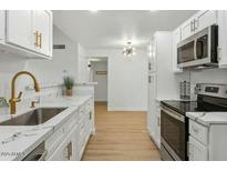 Modern kitchen with white cabinets, stainless steel appliances, and quartz countertops at 623 W Guadalupe Rd # 223, Mesa, AZ 85210