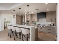 Beautiful kitchen featuring a quartz island with seating, stainless steel appliances, and modern cabinetry at 7175 E Camelback Rd # 601, Scottsdale, AZ 85251