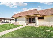 Cute stucco home with a grassy yard and covered walkway at 8131 N 107Th Ave # 76, Peoria, AZ 85345