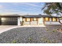 Updated mid-century modern home with dark gray garage door and light-colored exterior at 1720 W Sunnyslope Ln, Phoenix, AZ 85021