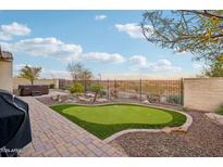 Landscaped backyard featuring a putting green, hot tub, and expansive views at 2317 N Beverly Pl, Buckeye, AZ 85396