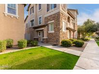 Tan three-story townhome with stone accents and landscaping at 4095 E Jasper Dr, Gilbert, AZ 85296