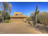 Desert landscape surrounds this tan stucco home with a two-car garage at 7800 E Boulders Pkwy # 9, Scottsdale, AZ 85266