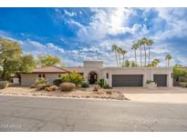 Beautiful desert home with stucco exterior, two-car garage, and mature landscaping at 8641 E Clubhouse Way, Scottsdale, AZ 85255