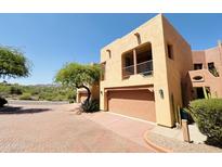 View of a two-story stucco home with a two-car garage, desert landscaping, and mountain views at 13227 N Mimosa Dr # 117, Fountain Hills, AZ 85268