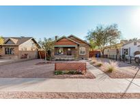 Charming brick home with a renovated front porch and well-maintained landscaping at 1815 N Dayton St, Phoenix, AZ 85006