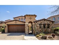 Inviting exterior with stone accents and a large wooden garage door at 19627 N 101St St, Scottsdale, AZ 85255