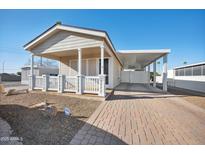 Tan single-story home with covered porch, carport, and well-maintained landscaping at 201 S Greenfield Rd # 353, Mesa, AZ 85206