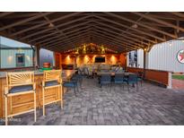 Covered patio features a built-in bar, seating, and a large TV at 510 E Desert Hills Estate Dr, Phoenix, AZ 85086