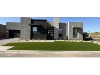Stunning modern home boasts stylish architecture, desert landscaping, and lush artificial turf at 5748 E Moura Dr, Cave Creek, AZ 85331