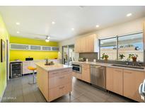 Modern kitchen featuring light wood cabinets, a large island, and stainless steel appliances at 2856 E Cochise Rd, Phoenix, AZ 85028
