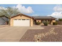 House exterior features a tan facade, solar panels, and a landscaped front yard at 7202 W Carol Ave, Peoria, AZ 85345