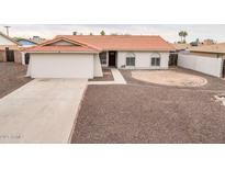 Single story home with a large driveway and desert landscaping at 8709 W Monroe St, Peoria, AZ 85345