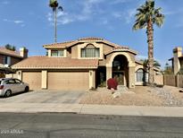 Two-story house with three-car garage and landscaped yard at 938 W Iris Dr, Gilbert, AZ 85233