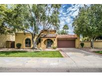 Spanish style home with landscaped yard and two-car garage at 10473 N 87Th Pl, Scottsdale, AZ 85258