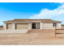 New single-story home with three-car garage and desert landscaping at 10662 S 297Th Ave, Palo Verde, AZ 85343