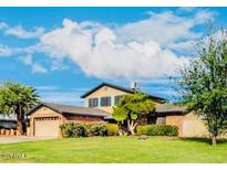 Charming two-story home with a well-manicured lawn, mature trees, and attached two car garage at 11051 N 53Rd Ave, Glendale, AZ 85304