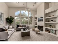 Spacious living room with vaulted ceilings, fireplace, and large windows at 11664 E Caron St, Scottsdale, AZ 85259