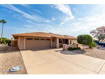 Tan single story house with a two-car garage and landscaped yard at 13438 W Ashwood Dr, Sun City West, AZ 85375