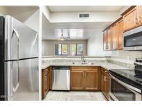 Modern kitchen with stainless steel appliances and granite countertops at 21655 N 36Th Ave # 106, Glendale, AZ 85308