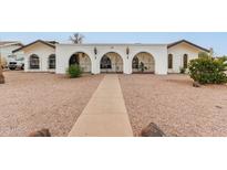 White stucco house with arched entryway and nicely landscaped yard at 2407 E Encanto St, Mesa, AZ 85213