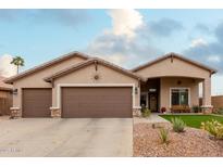 Single-story house with two-car garage and landscaped front yard at 5711 W Lydia Ln, Laveen, AZ 85339