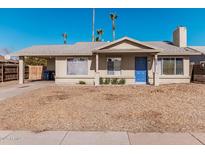 Single story home with blue door and landscaped yard at 604 W Emerald Ave, Mesa, AZ 85210