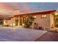 Desert landscaping surrounds this single-story home with a large driveway at 617 S Camino Saguaro --, Apache Junction, AZ 85119