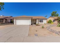 Single-story home with a two-car garage and desert landscaping at 6602 W Desert Cove Ave, Glendale, AZ 85304