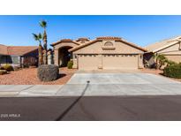 Tan two-story house with tile roof, two-car garage, and desert landscaping at 1562 W Flintlock Way, Chandler, AZ 85286