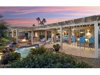 Expansive backyard oasis with a pool, fire pit, and outdoor kitchen at 15891 W Avalon Dr, Goodyear, AZ 85395