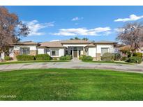 Single-story home with stone accents and a manicured lawn at 2536 E Wood Pl, Chandler, AZ 85249