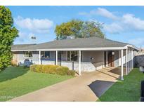 House exterior featuring a landscaped lawn and carport at 7806 E Loma Land Dr, Scottsdale, AZ 85257