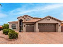 Two-story house with brown exterior, three-car garage, and landscaped front yard at 10035 E Diamond Dr, Sun Lakes, AZ 85248