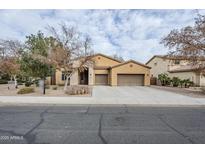 Tan two-story house with a three-car garage and nicely landscaped front yard at 1060 W Silver Creek Rd, Gilbert, AZ 85233