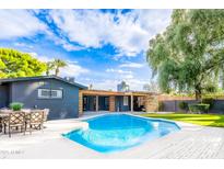 Inviting backyard featuring a sparkling pool, lush greenery, and covered patio area, perfect for outdoor entertaining at 2942 N 81St Pl, Scottsdale, AZ 85251