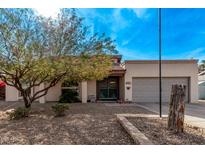 Single-story home with a gray garage door and landscaped front yard at 3921 W Sharon Ave, Phoenix, AZ 85029