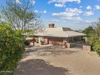 A charming home with a red brick driveway and mature trees in a sunny, vibrant setting at 4024 E Hermosa Vista Dr, Mesa, AZ 85215