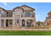 Two-story townhome with balcony, front patio, and landscaped lawn at 9832 E Wavelength Ave, Mesa, AZ 85212