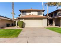 Two-story house with a beige exterior, attached garage, and landscaped lawn at 10036 W Montecito Ave, Phoenix, AZ 85037