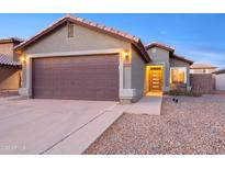 House exterior featuring a two-car garage and well-maintained landscaping at 12222 W Larkspur Rd, El Mirage, AZ 85335