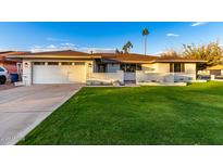 Ranch style home with a white brick facade, attached garage, and well-manicured lawn at 1164 E Westchester Dr, Tempe, AZ 85283