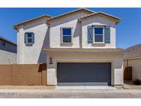 Two-story home featuring stucco siding, blue shutters, and a two-car garage under a bright blue sky at 14644 W Sand Hills Rd, Surprise, AZ 85387