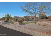 Beautiful single-story home with desert landscaping, mature trees, and a well-manicured lawn at 18009 W Denton Ave, Litchfield Park, AZ 85340