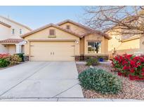 Tan house with two-car garage and landscaping at 22708 N Kennedy Dr, Maricopa, AZ 85138